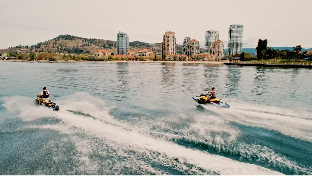 Two GTI Sea-Doos on the lake in front of downtown Kelowna’s towers