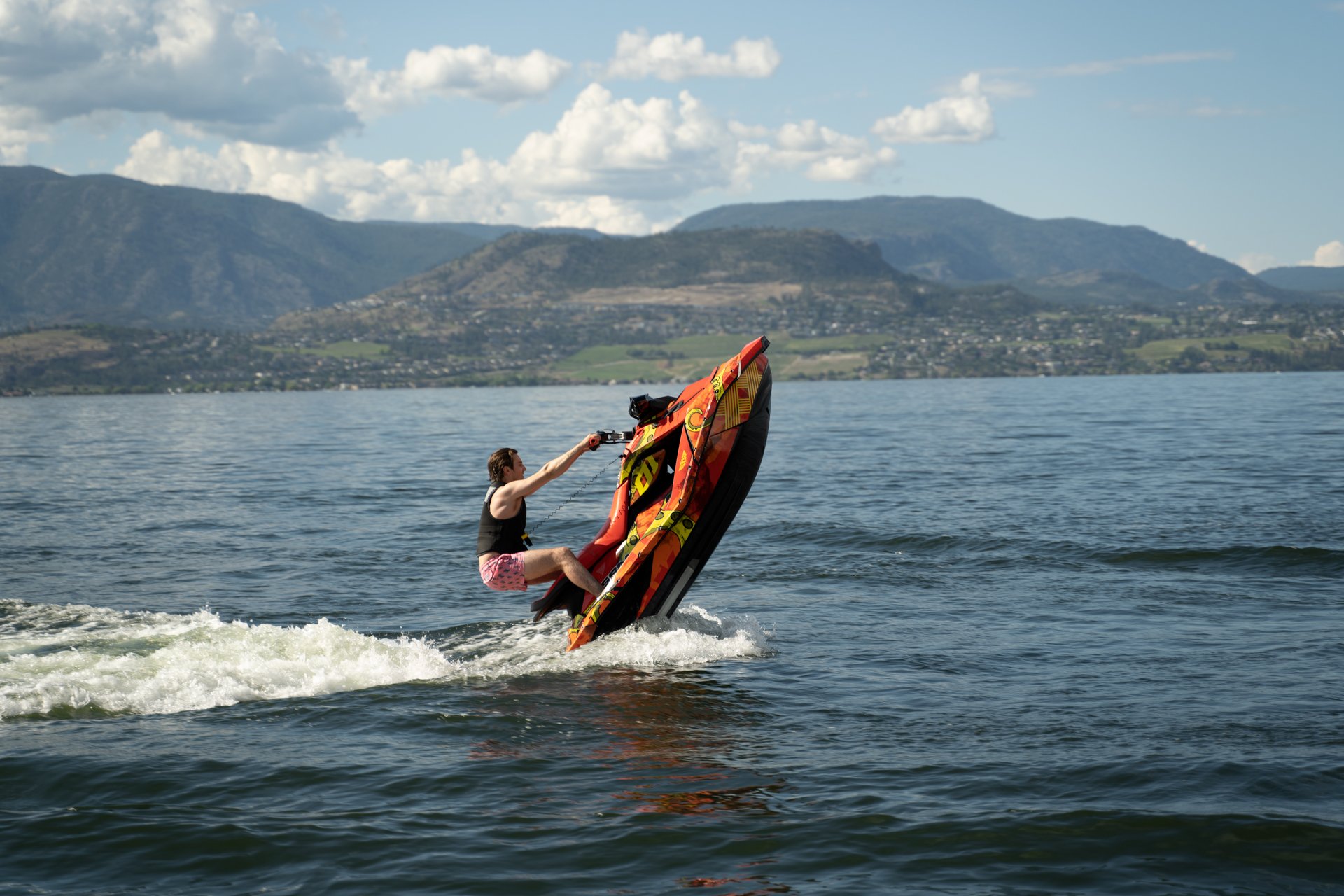 A rider standing on a Spark Trixx with its nose lifted out of the water